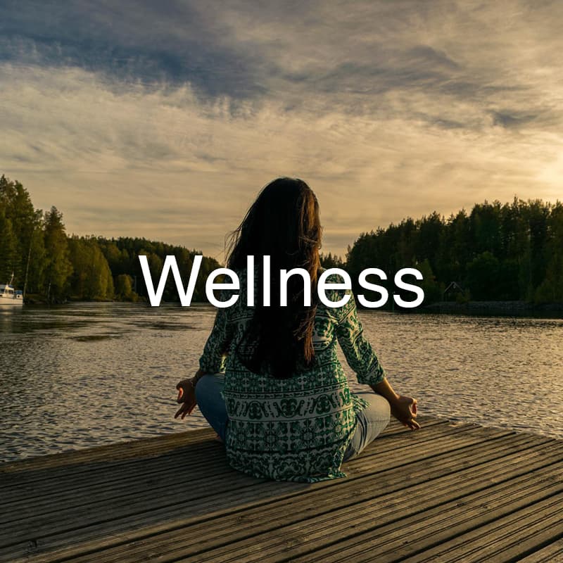 Woman meditating on Wellness on a dock